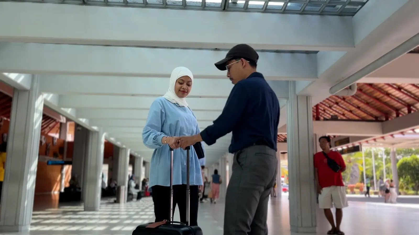 A driver greeting a traveller in an airport arrivals hall