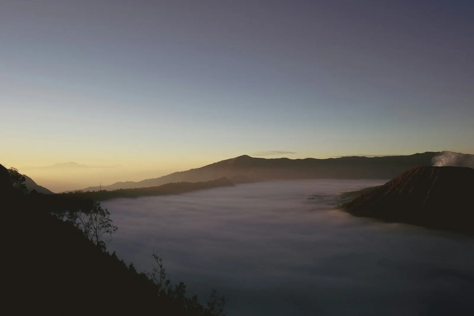 Fog filling the Tengger caldera before sunrise, Mount Batok at its edge