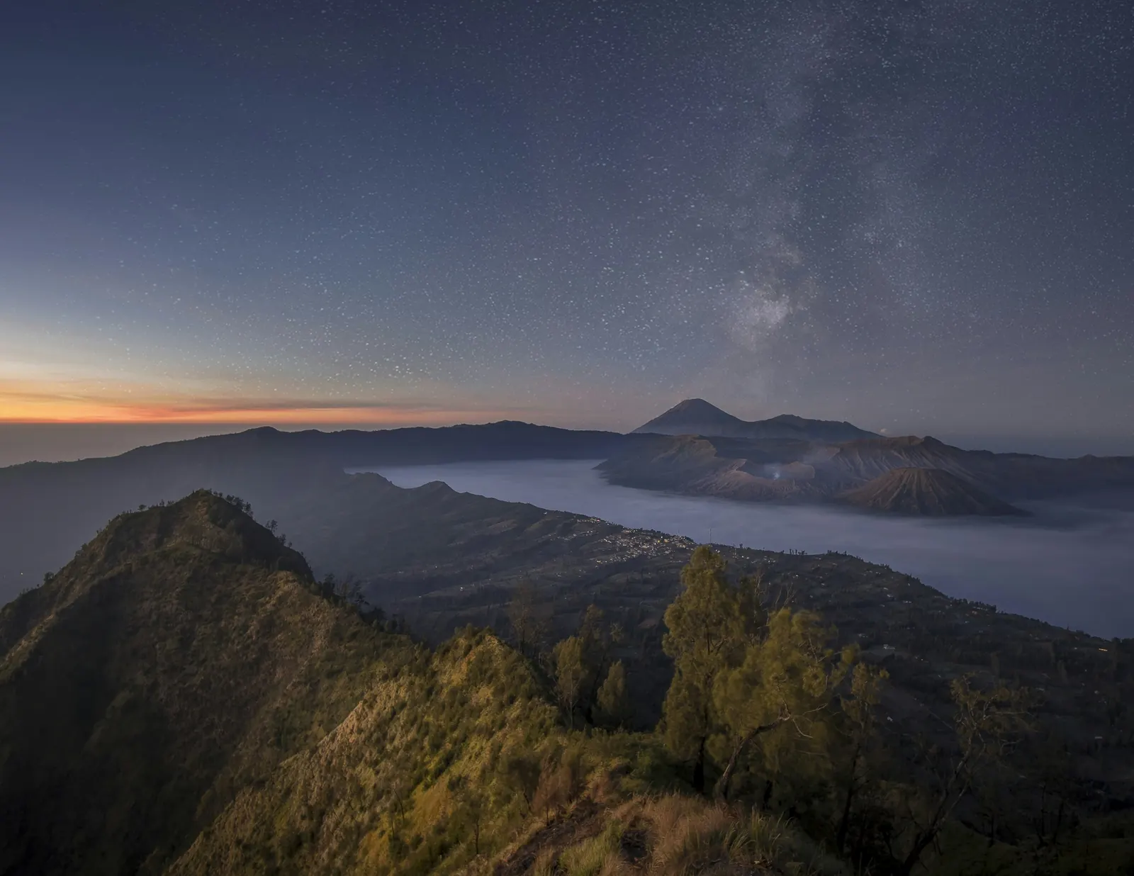 The Milky Way over the Tengger caldera before dawn, Mount Bromo and Batok in the mist