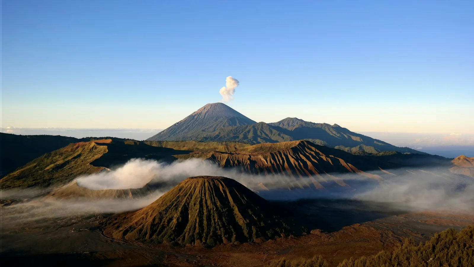 Mount Batok and the Tengger caldera at sunrise, Mount Semeru venting on the horizon