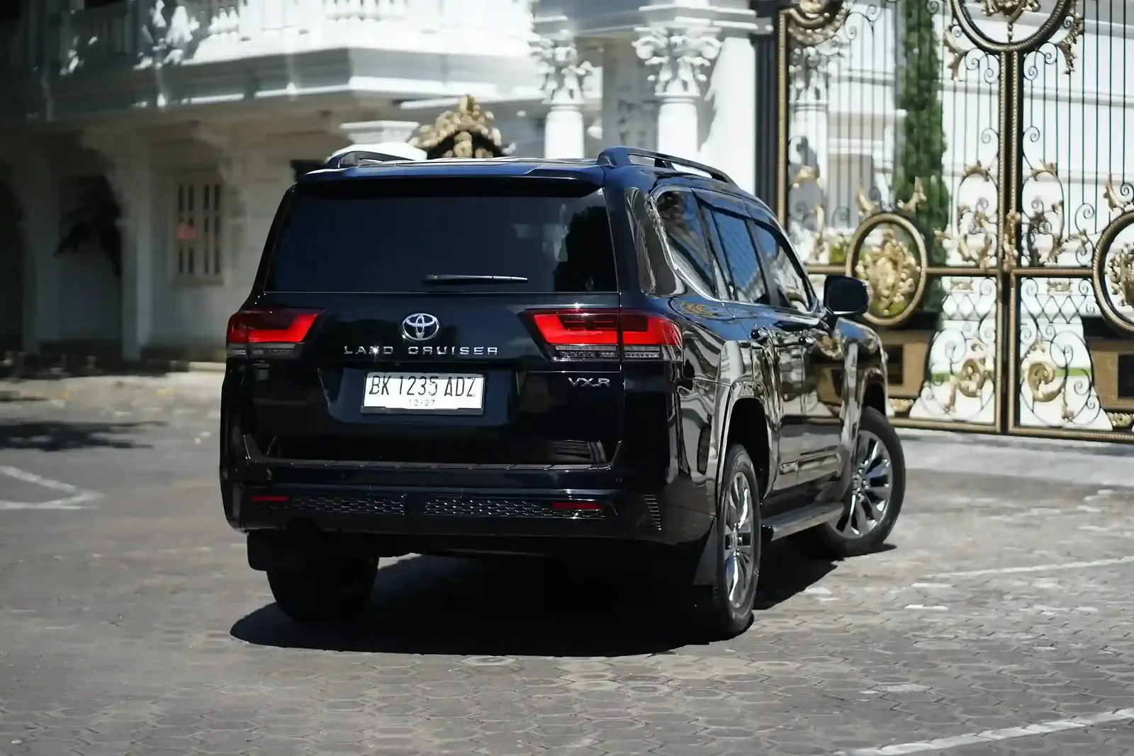 A black Land Cruiser parked in a hotel driveway